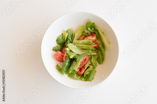 High angle view of tomato and lettuce salad in white bowl on table
