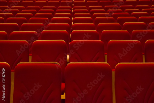 Empty red chairs in movie theater without people