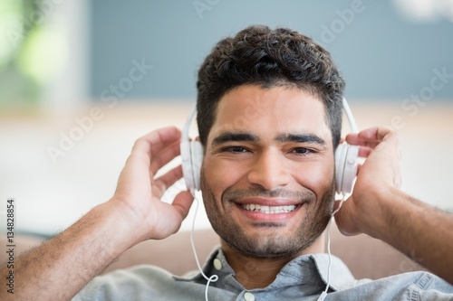 Man listening to music on headphones in living room at home