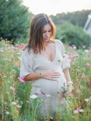 pregnant woman standing in flowers