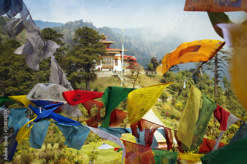 Bhutan view. Buddhist praying flags and Memorial at Dochula pass, VIII century, for honour of the Bhutanese soldiers in the Thimpu city, beautiful landscape and cloudy sky on background.