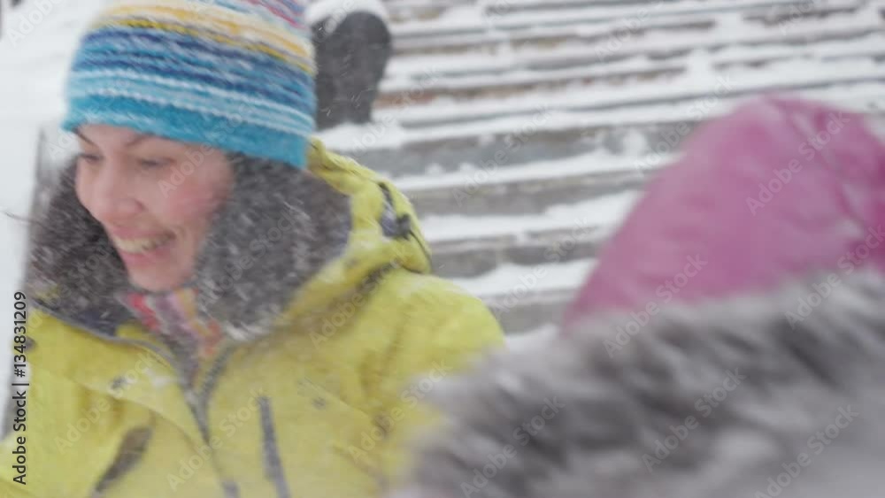 Happy child and young woman playing with snow in winter park.