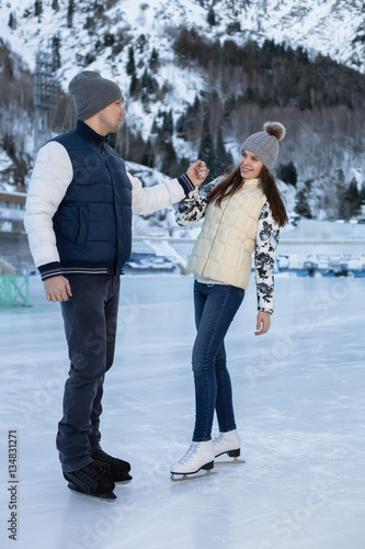 Loving couple skating together holding hands