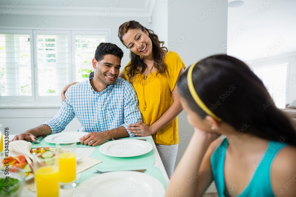 Daughter and parents having meal on table at home Daughter and parents having meal on table at home