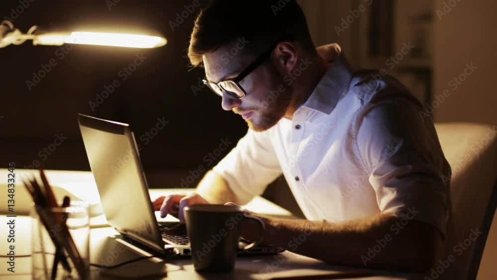 man with laptop and papers working at night office man with laptop and papers working at night office