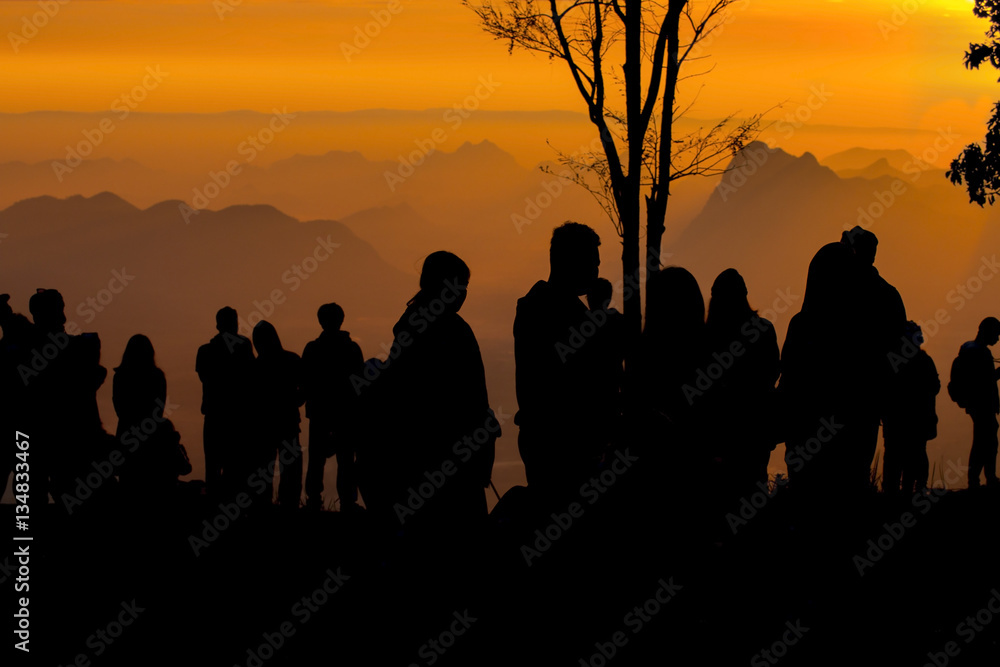 Fototapeta premium silhouette of people the cliff and looking at the valley and mountains with sunrise in the morning