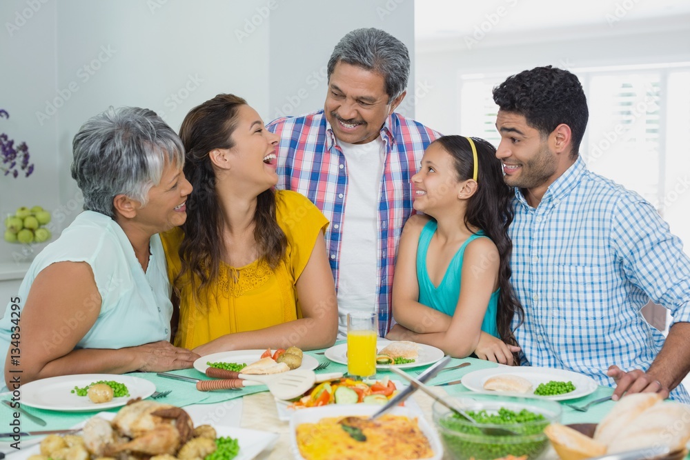 Happy multi generation family having meal on table at home Happy multi generation family having meal on table at home