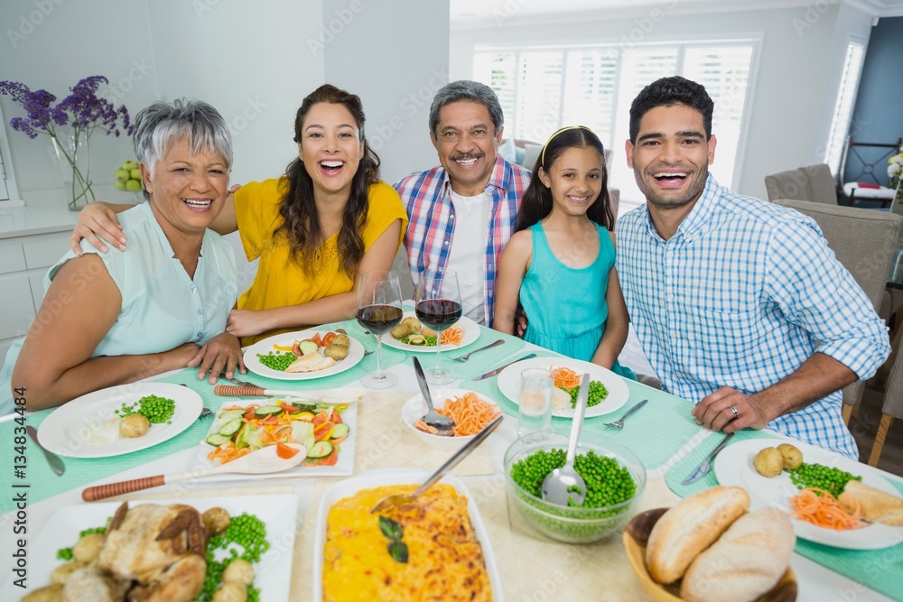Happy multi generation family having meal on table at home Happy multi generation family having meal on table at home