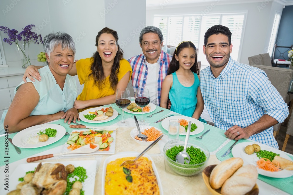 Happy multi generation family having meal on table at home