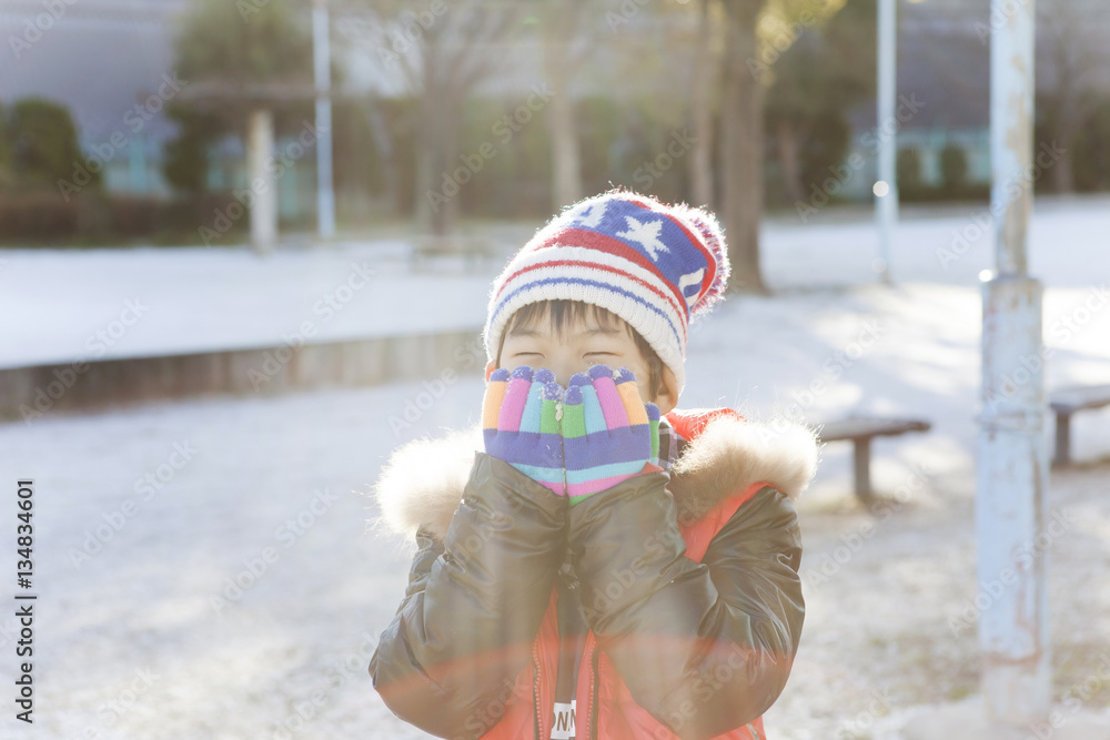 雪の公園で遊ぶ子供