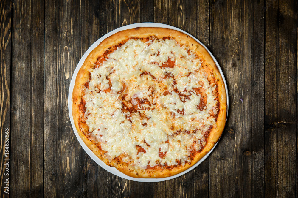 Top view of Italian rustic PIZZA on wooden table background Top view of Italian rustic PIZZA on wooden table background