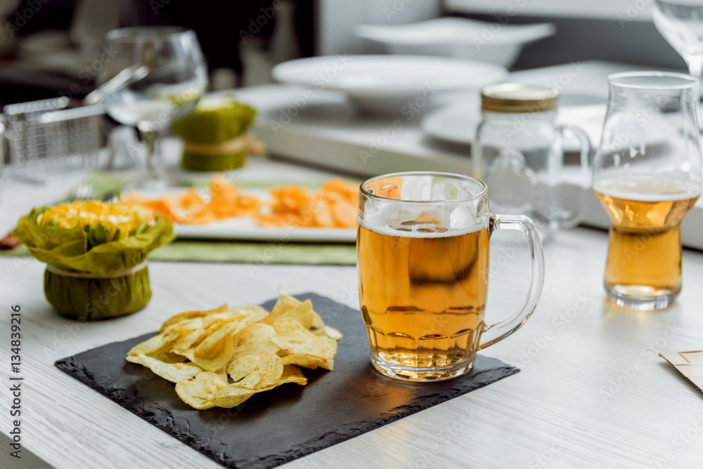Beer and chips on the large white table Beer and chips on the large white table