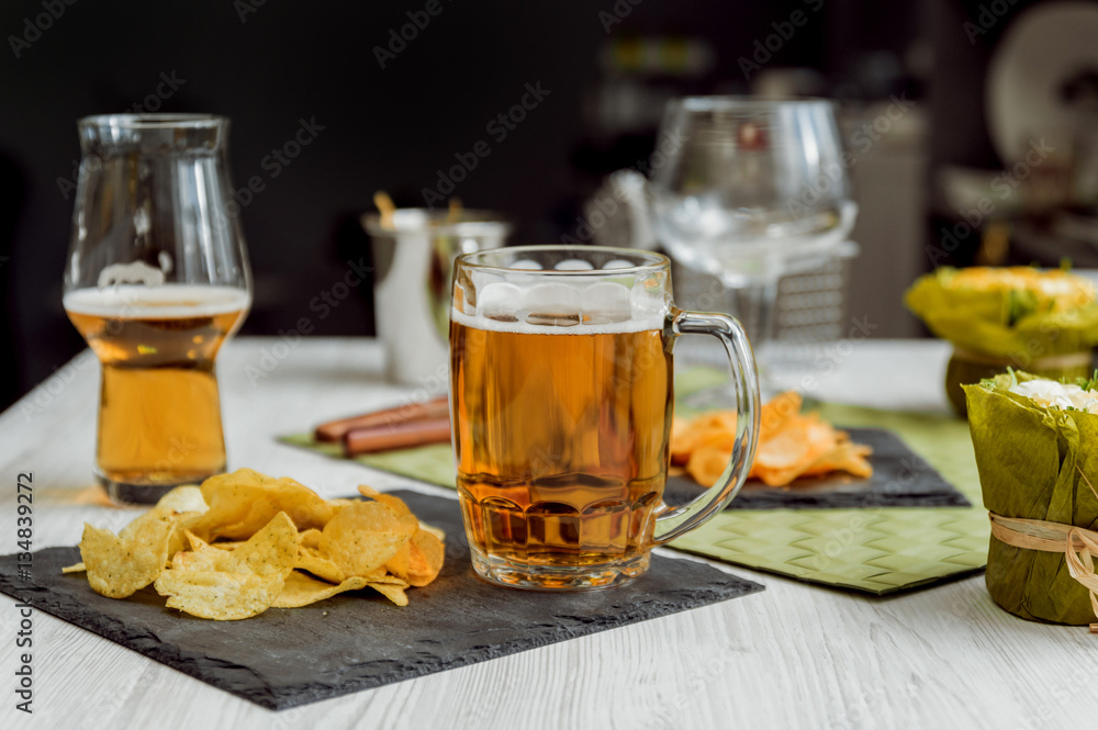 Beer and chips on the large white table Beer and chips on the large white table