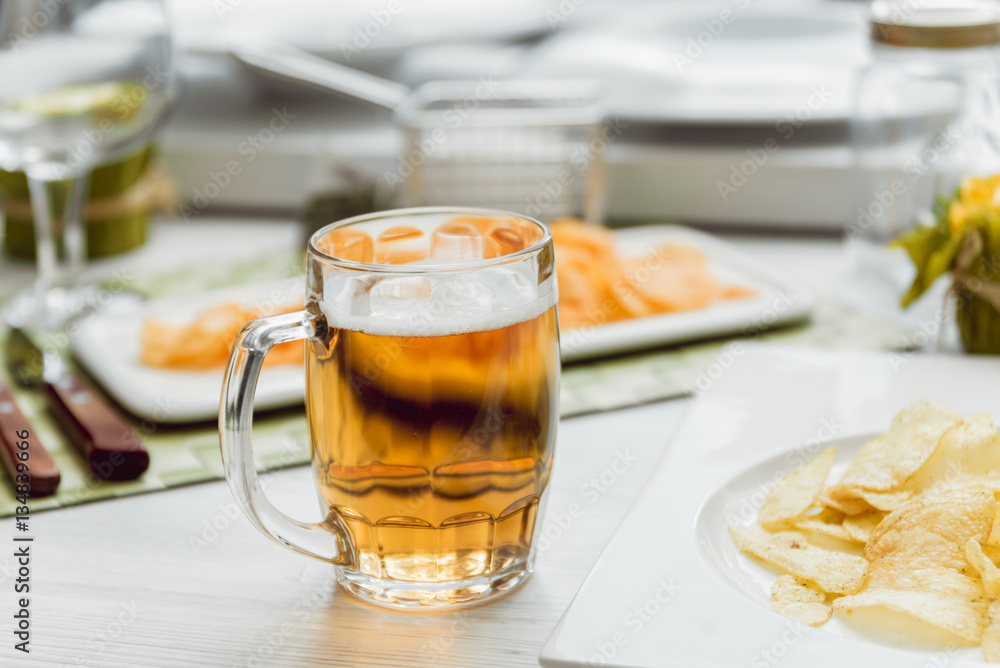 Beer and chips on the large white table Beer and chips on the large white table