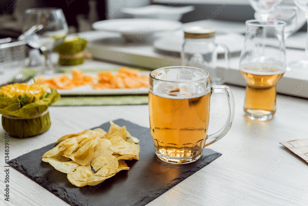 Beer and chips on the large white table Beer and chips on the large white table