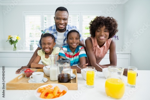 Kids and parents having breakfast on table at home