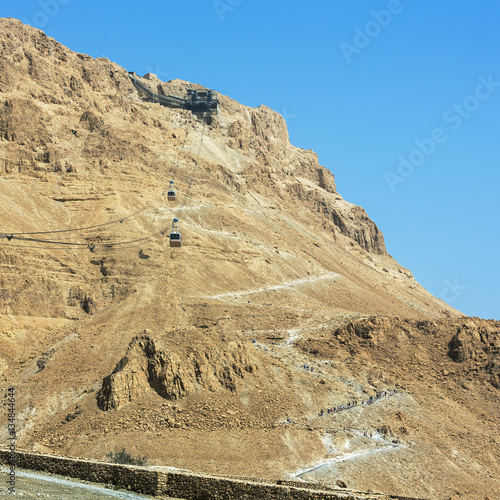 The cable car transporting passengers and hiking trail in ancient fortress Masada - Israel photo