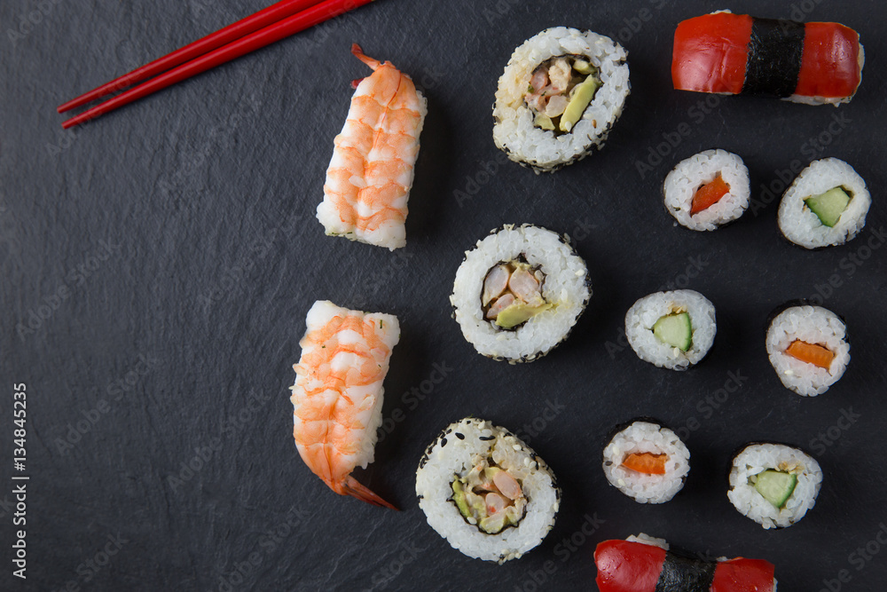 Sushi platter with chopsticks on dark background Sushi platter with chopsticks on dark background