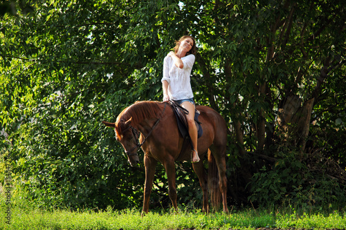 Beautiful young equestrian woman in summer country side  © horsemen