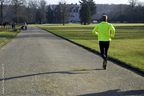 man in fluorescent jacket running in the park 