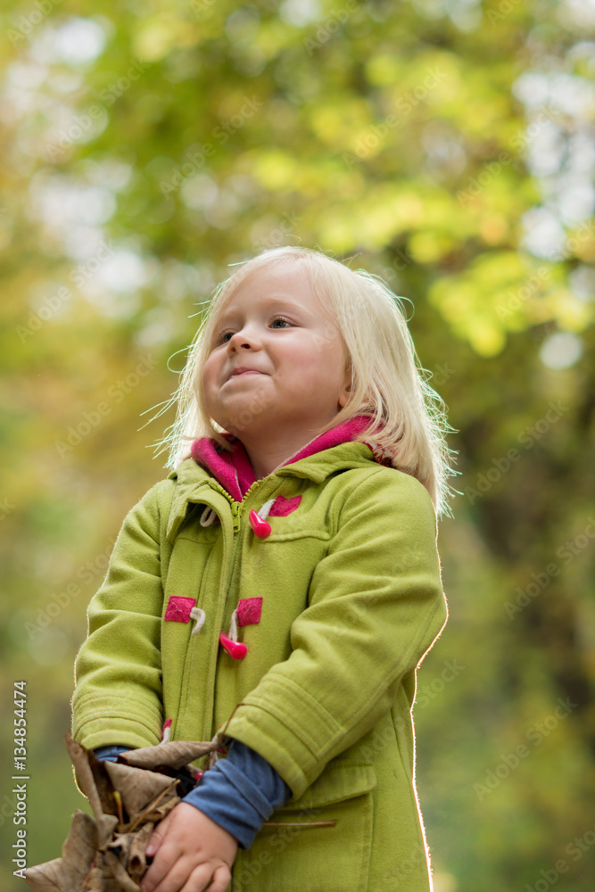 Girl in Green Coat Carrying Dried Leaves Girl in Green Coat Carrying Dried Leaves