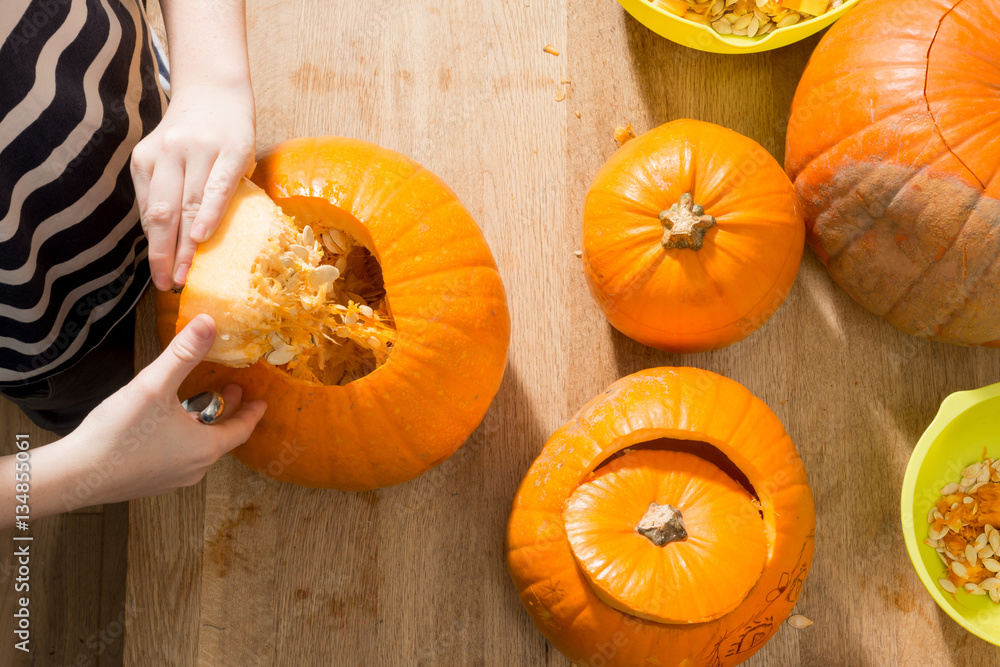 Overhead of Hands Pulling Crown Off a Pumpkin Overhead of Hands Pulling Crown Off a Pumpkin