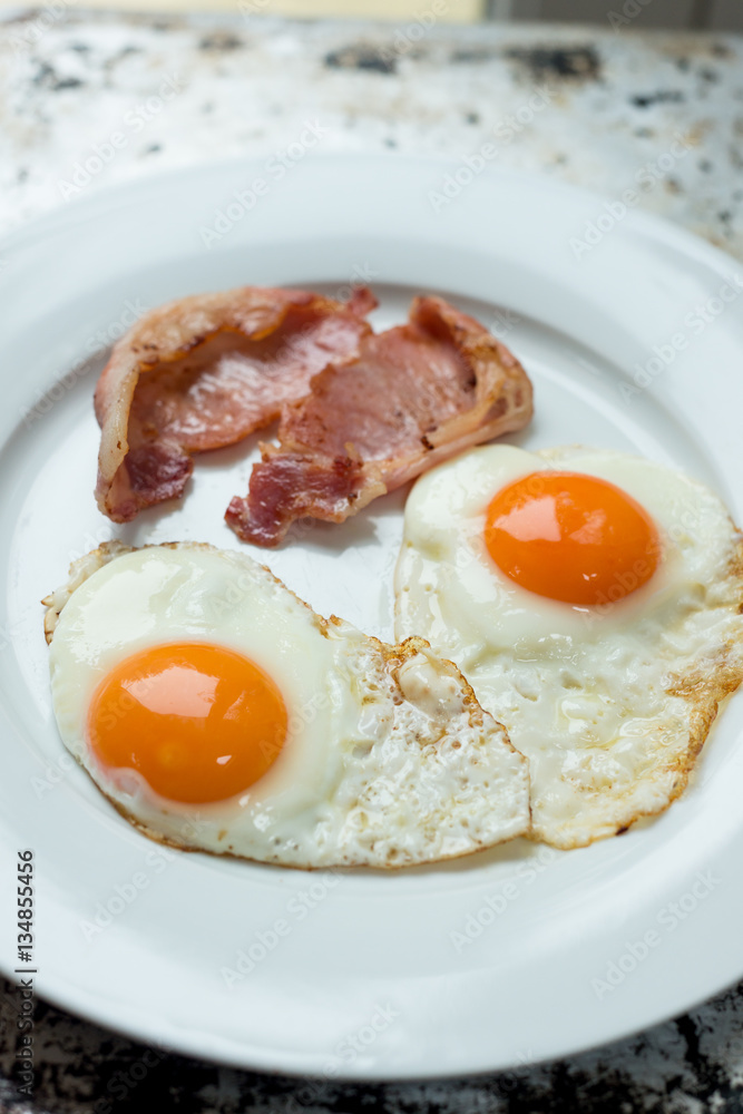Cooked Bacon and Eggs in White Plate Cooked Bacon and Eggs in White Plate