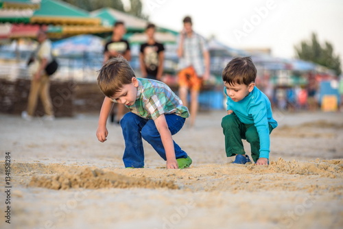 Two happy caucasian kids, brothers, playing together with toy ca photo