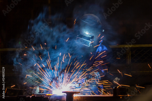  Worker at the factory is welding assembly automotive part 
