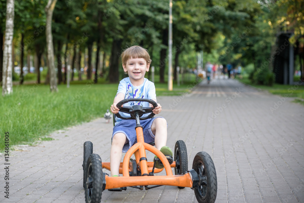 Little preschool boy driving big toy sports car and having fun, outdoors. Little preschool boy driving big toy sports car and having fun, outdoors.
