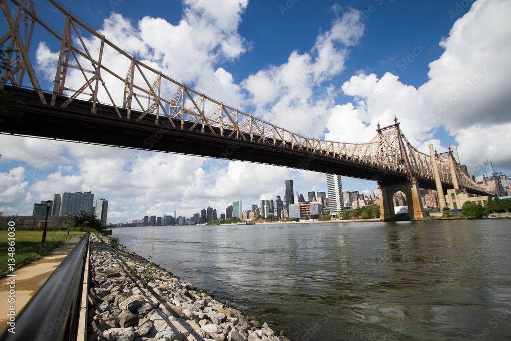 Queensboro bridge over river and shore with cloudy sky