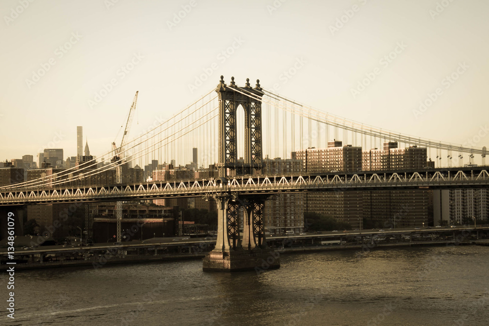 Manhattan bridge over the river and buildings in old vintage style, New York