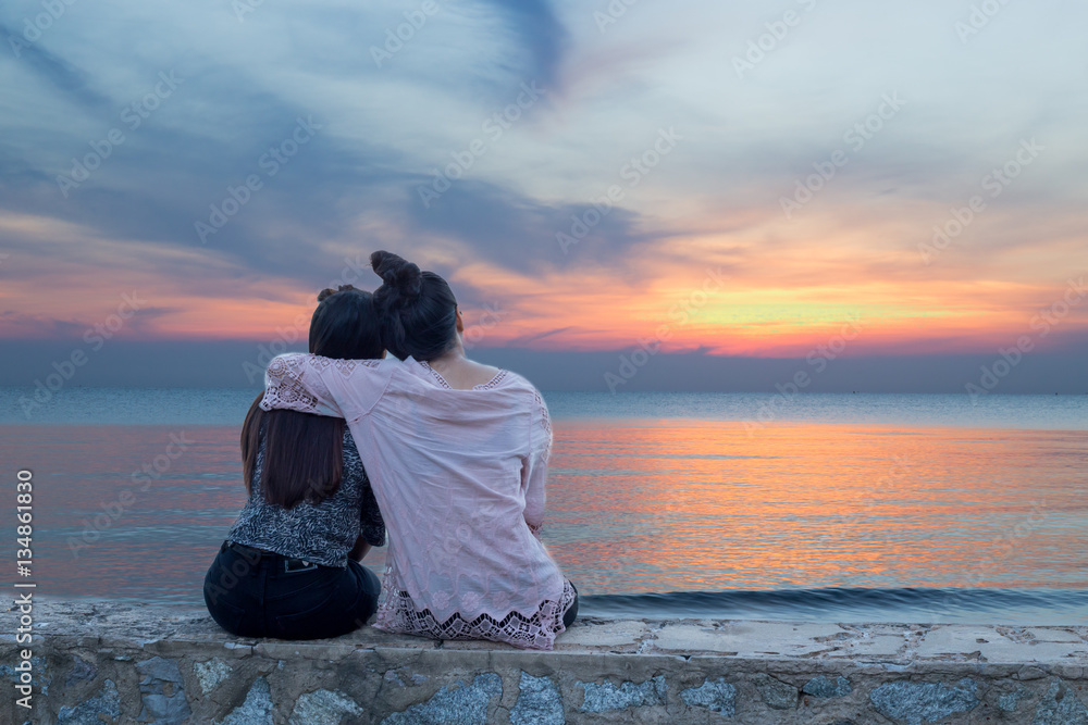 Women sit back hug