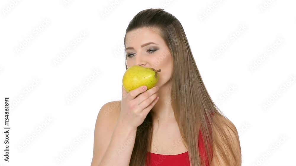 beautiful girl eats ripe pear on white background beautiful girl eats ripe pear on white background