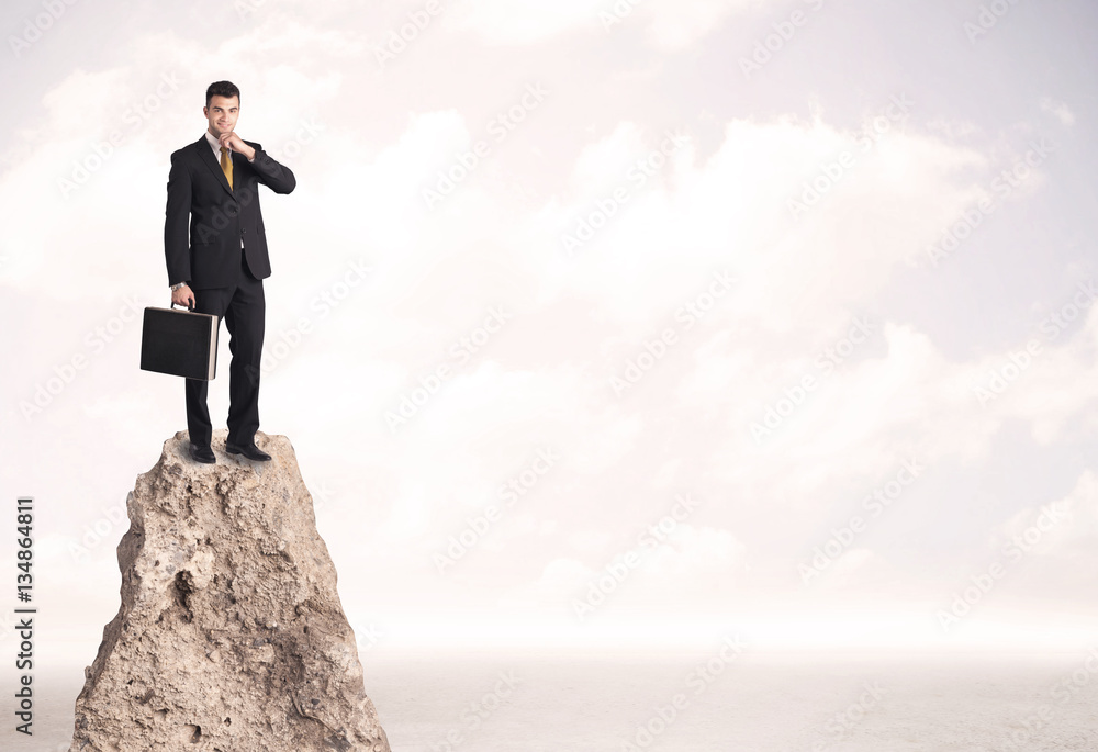 Happy businessman standing on cliff Happy businessman standing on cliff