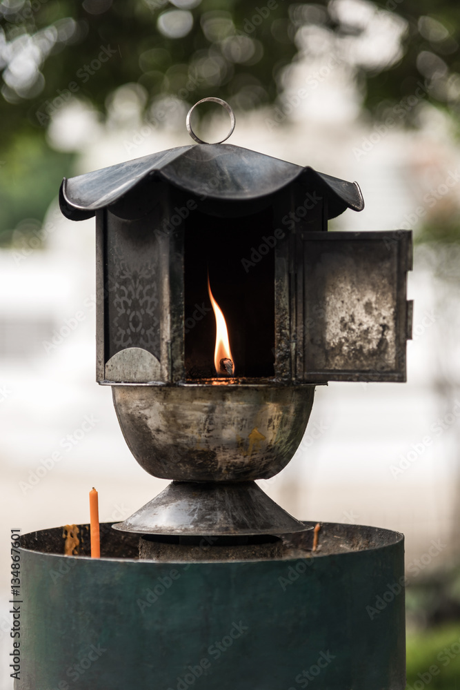 Traditional oil lamp lit at the buddhist temple.
