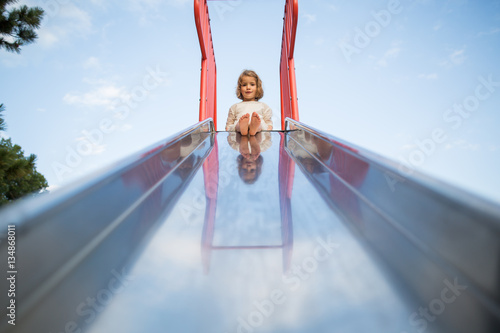 Girl sitting on top of slide  photo