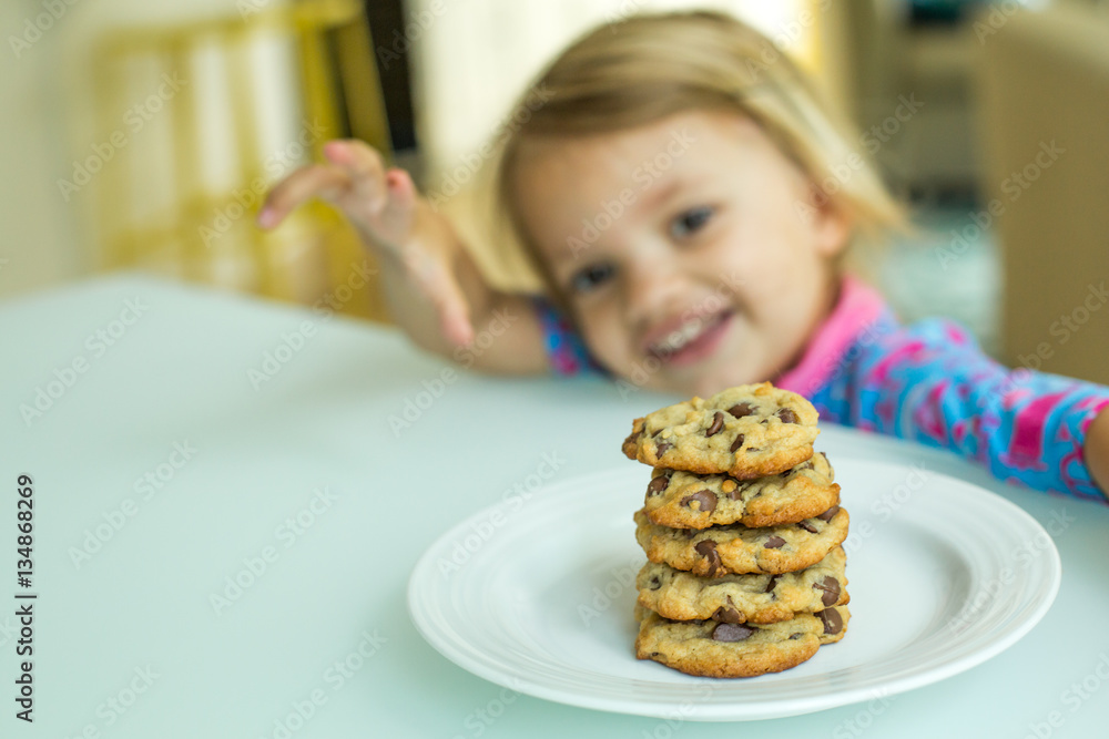 Pile of chocolate chip cookies and kid in background Pile of chocolate chip cookies and kid in background