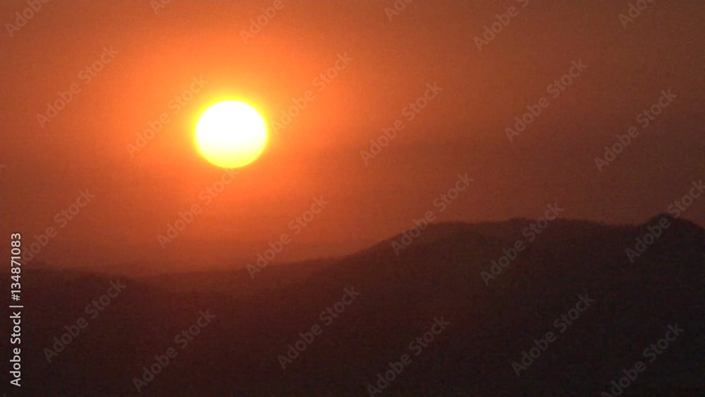 Red Sun Sets in Smoke over Mountains from Forest Fires Red Sun Sets in Smoke over Mountains from Forest Fires