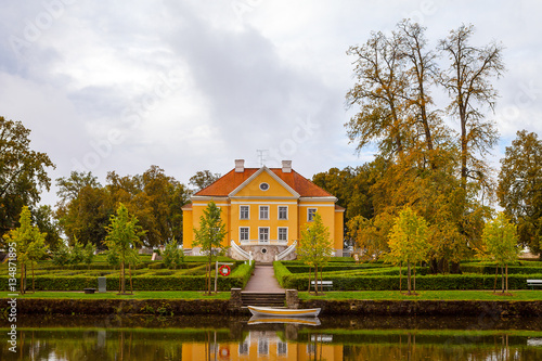 Beautiful and rich Palmse Manor in Estonia. Green bushes in park in front of manor.