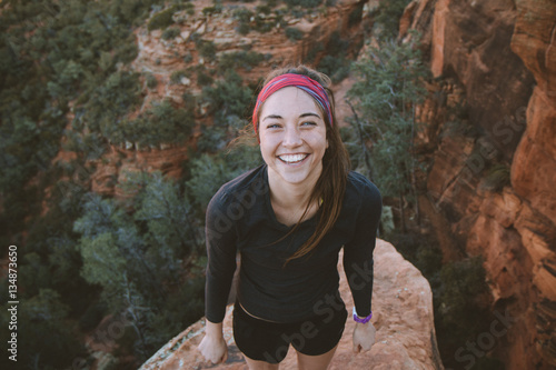 Over head view of young woman standing on a high rock 