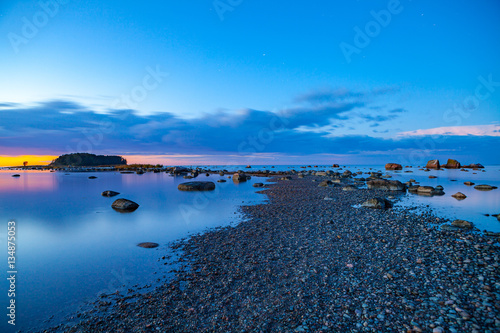 Seascape sunset with rocks and pebble coast of Baltic sea