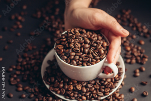 coffee beans in a cup and saucer