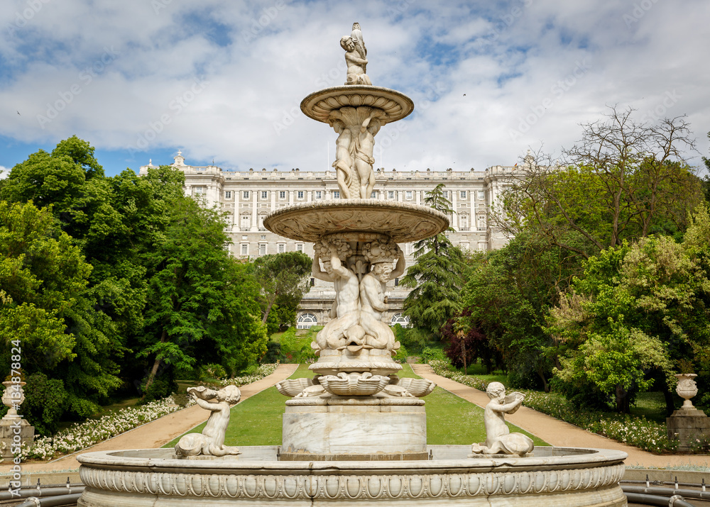 Close up view of a sculpture, with the royal palace of Madrid in