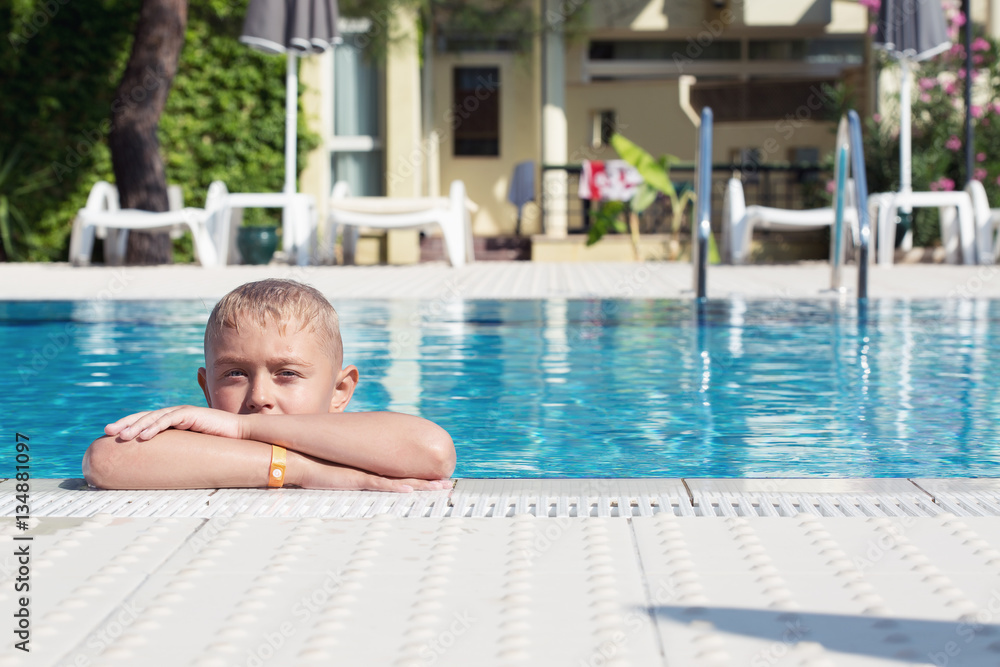 A cute blonde boy in a swimming pool