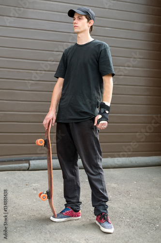 Teenage skateboarder standing
