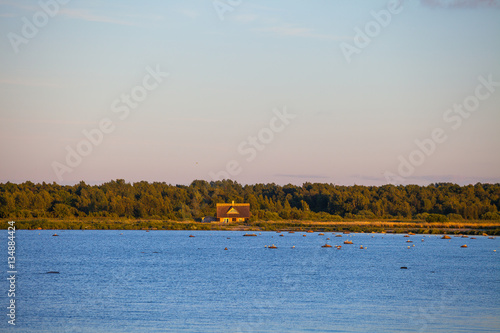 Fototapeta Naklejka Na Ścianę i Meble -  Small wooden house near Baltic sea at sunset