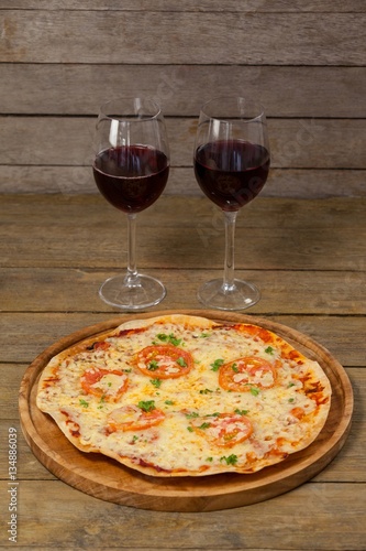 Delicious pizza with glasses of red wine