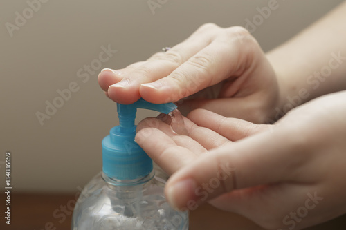 female hands using a hand sanitizer