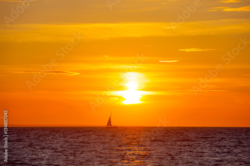 Beautiful orange sunset and boat on the Baltic sea © yegorov_nick